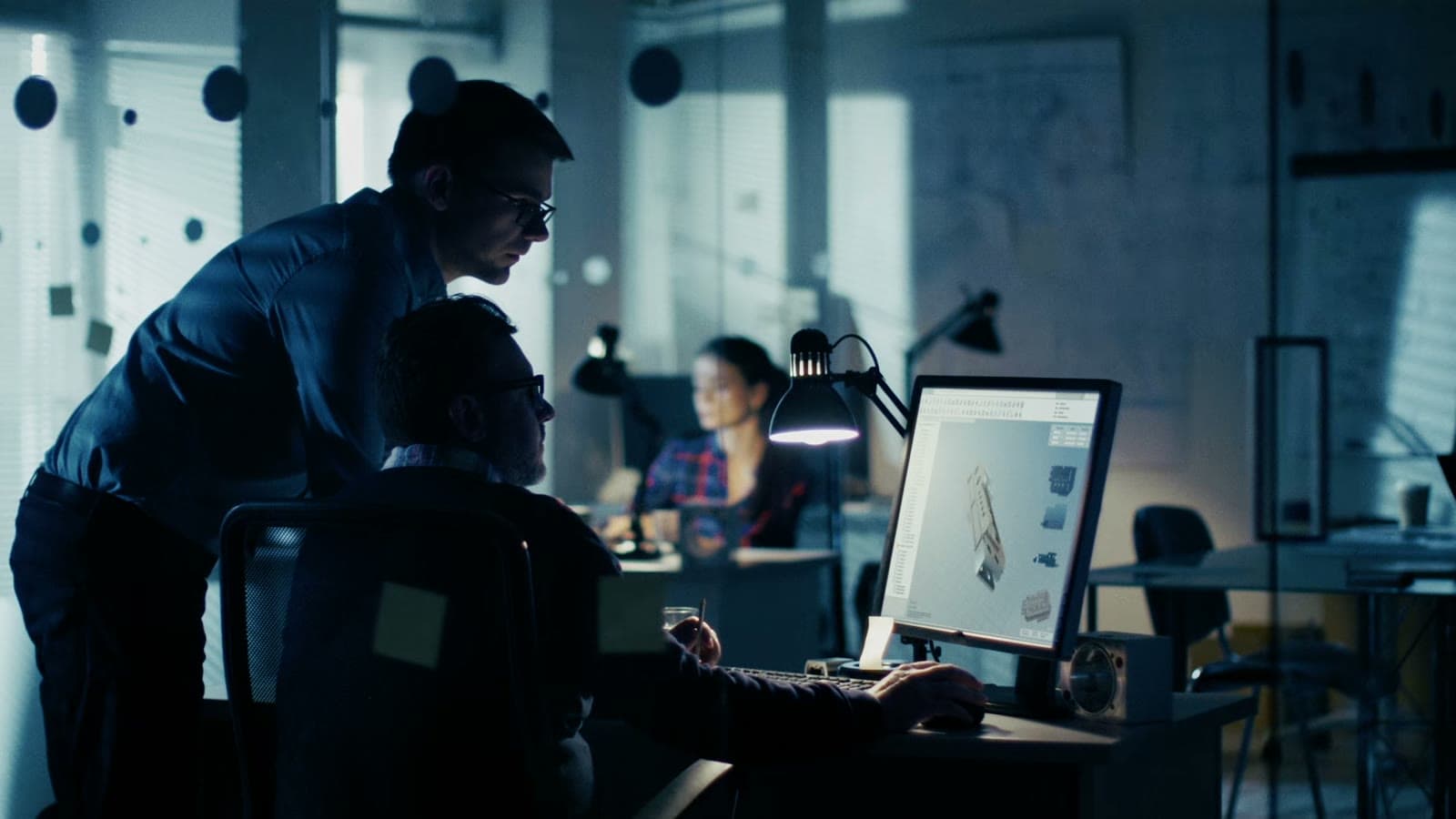 Two colleagues checking an order on screen in an office